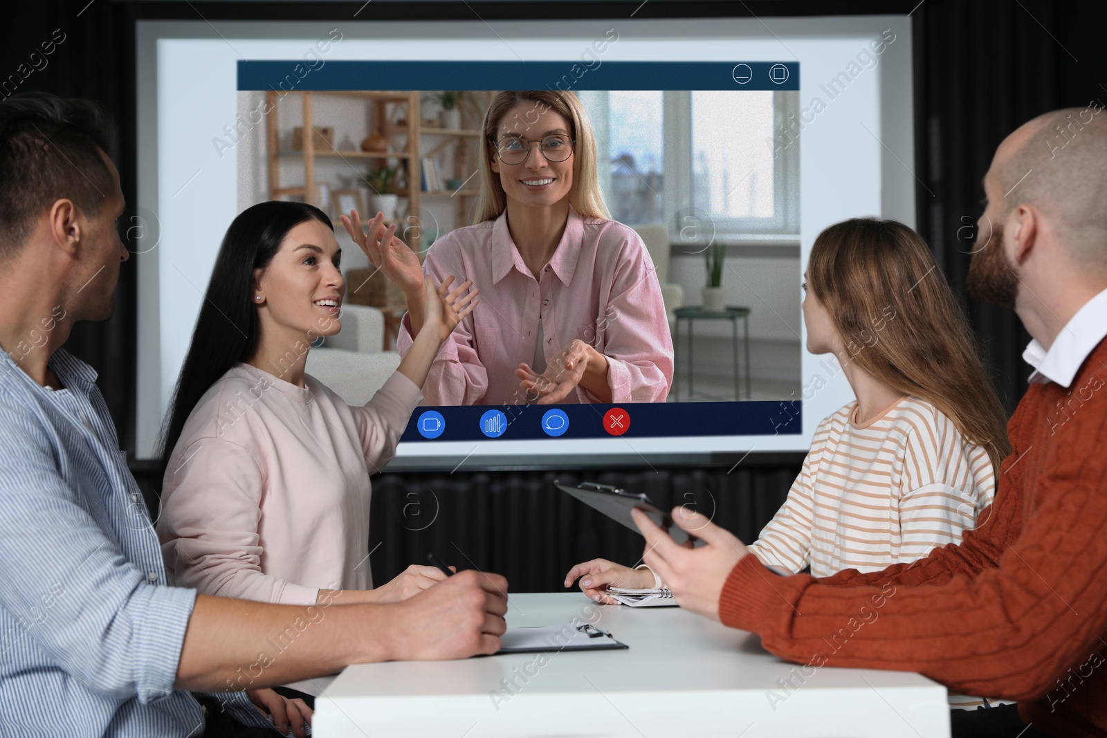 Speaker participating in lecture via online video chat. Audience in conference room with projection screen Image of Speaker participating in lecture via online video chat. Audience in conference room with projection screen