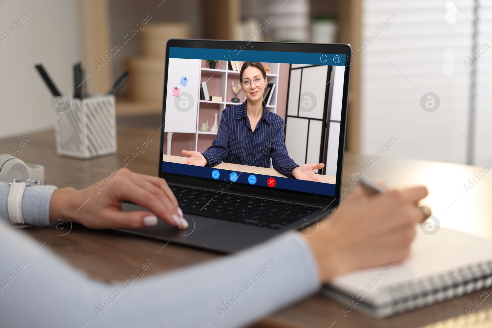 Woman listening to speaker via laptop online at table, closeup Image of Woman listening to speaker via laptop online at table, closeup
