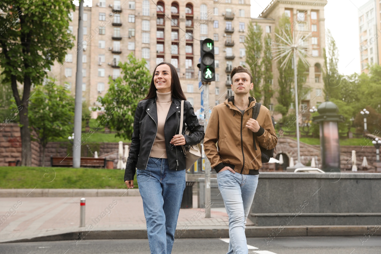 Young people crossing street at traffic lights Photo of Young people crossing street at traffic lights