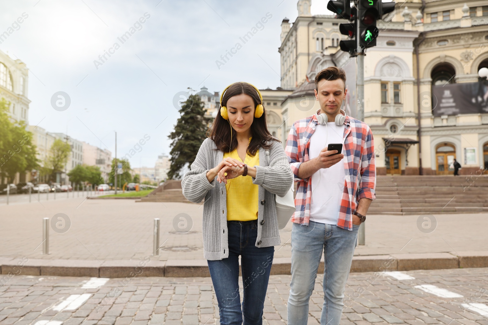 Young people crossing street at traffic lights Photo of Young people crossing street at traffic lights