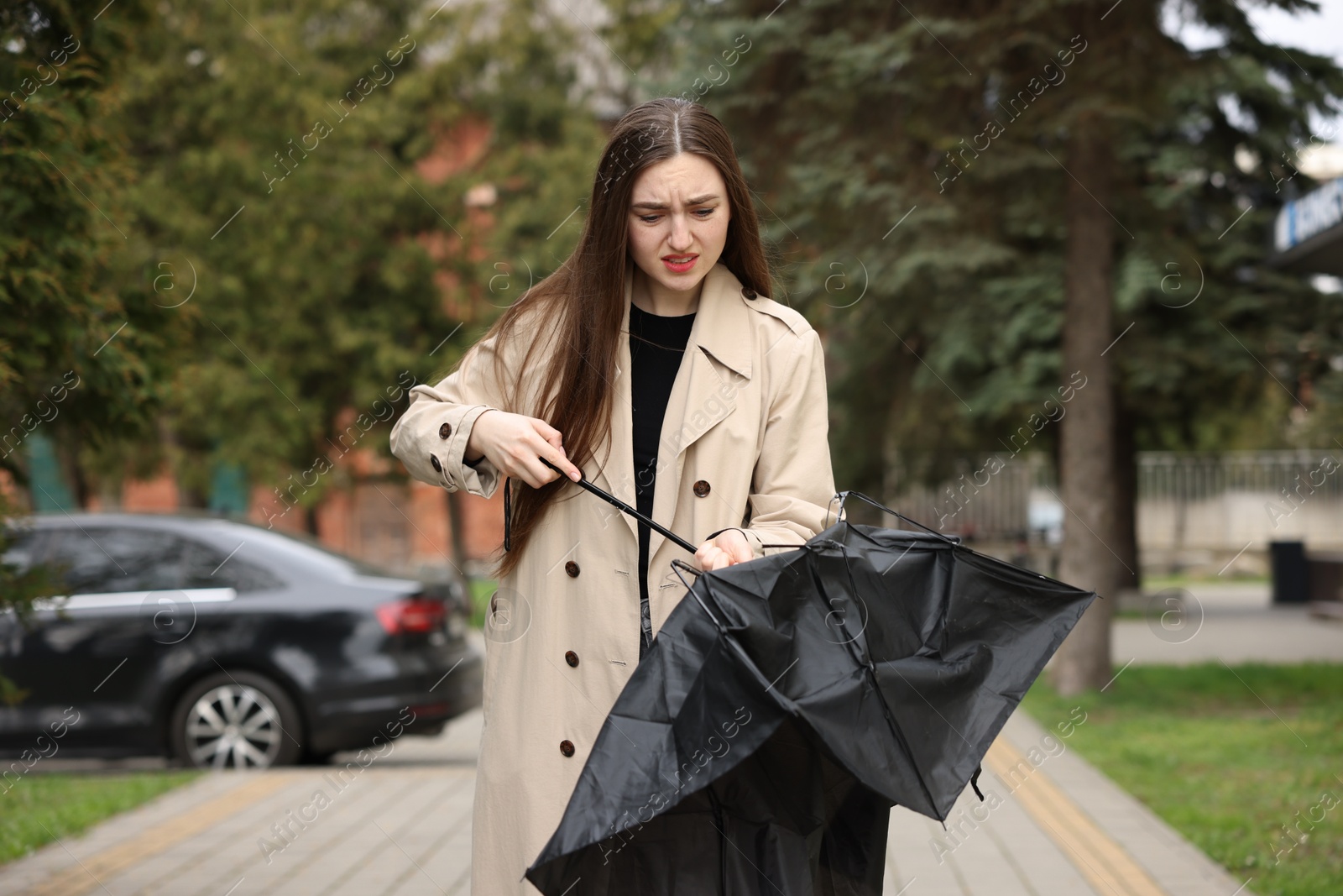 Sad woman with broken umbrella in park Photo of Sad woman with broken umbrella in park