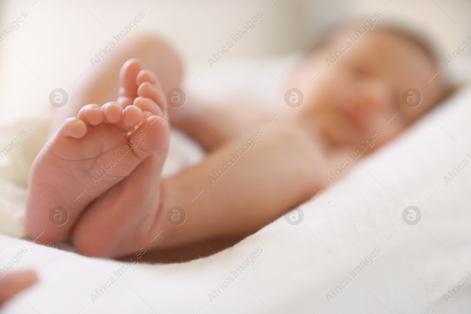 Little baby lying on bed indoors, selective focus Photo of Little baby lying on bed indoors, selective focus