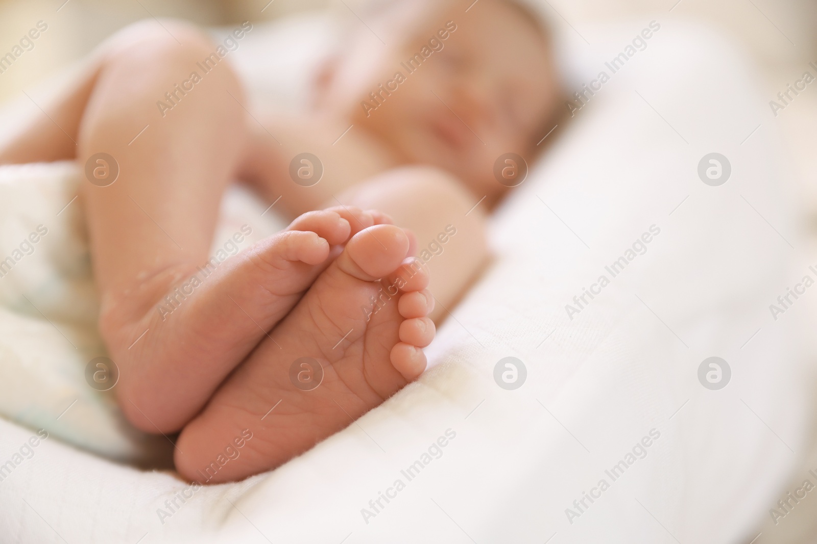 Little baby lying on bed indoors, selective focus. Space for text Photo of Little baby lying on bed indoors, selective focus. Space for text