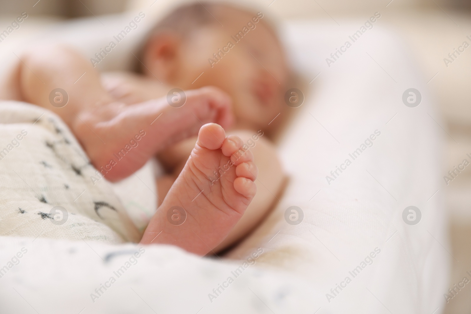 Little baby lying on bed indoors, selective focus. Space for text Photo of Little baby lying on bed indoors, selective focus. Space for text