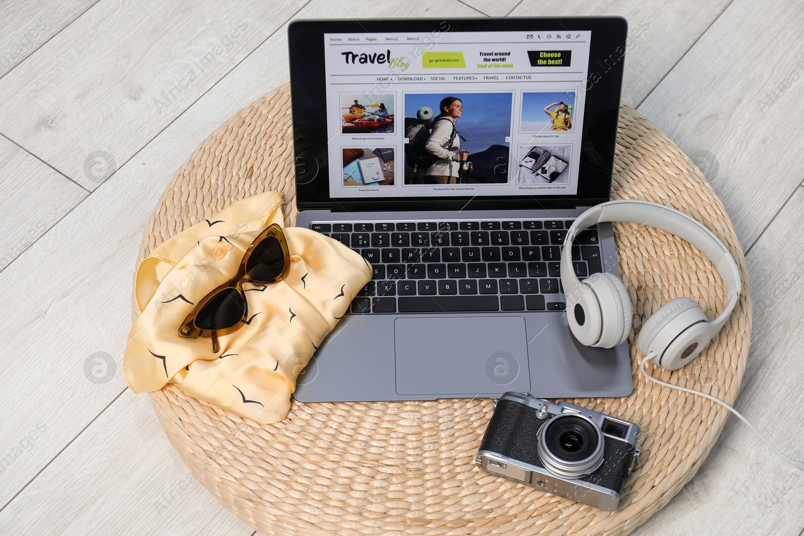 Laptop with travel blog web site, accessories, vintage camera and headphones on floor indoors, above view Photo of Laptop with travel blog web site, accessories, vintage camera and headphones on floor indoors, above view