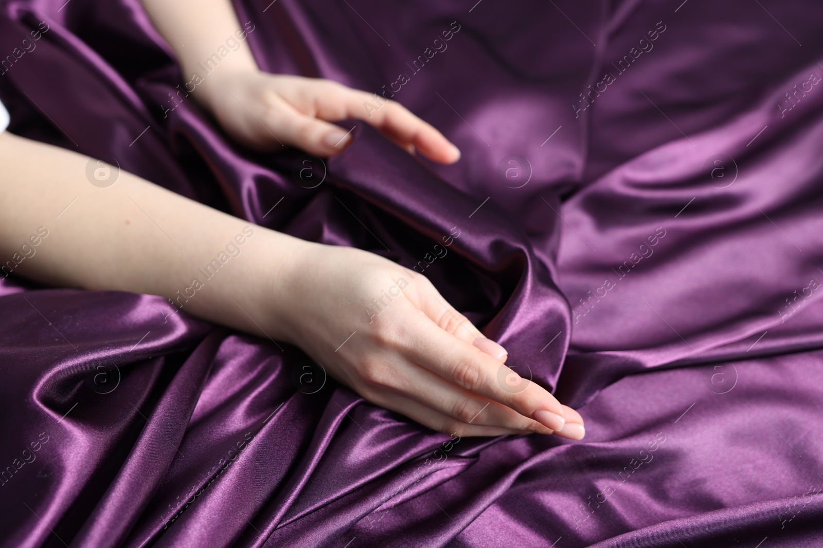 Woman on purple silk bed linens, closeup Photo of Woman on purple silk bed linens, closeup
