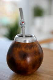 Photo of Traditional yerba mate tea on wooden table indoors, closeup