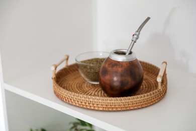 Photo of Traditional yerba mate tea on shelving unit indoors