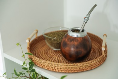 Photo of Traditional yerba mate tea on shelving unit indoors