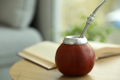 Photo of Traditional yerba mate tea on wooden table indoors, closeup