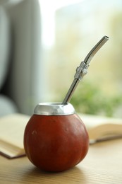 Photo of Traditional yerba mate tea on wooden table indoors