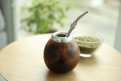 Photo of Traditional yerba mate tea on wooden table indoors