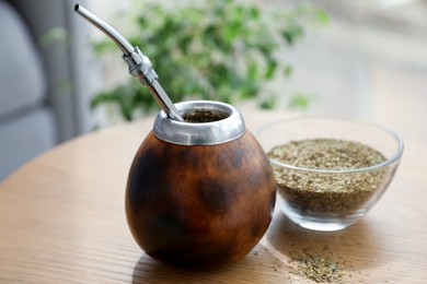Photo of Traditional yerba mate tea on wooden table indoors
