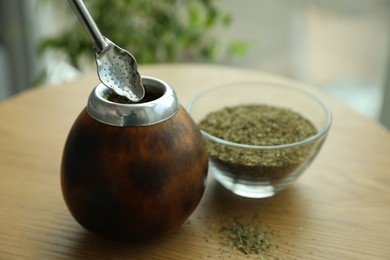 Photo of Traditional yerba mate tea on wooden table indoors, closeup