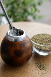 Photo of Traditional yerba mate tea on wooden table indoors, closeup
