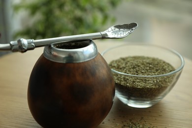 Photo of Traditional yerba mate tea on wooden table indoors, closeup