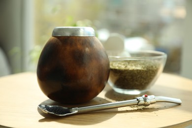 Photo of Traditional yerba mate tea on wooden table indoors, closeup