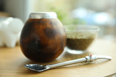 Photo of Traditional yerba mate tea on wooden table indoors, closeup