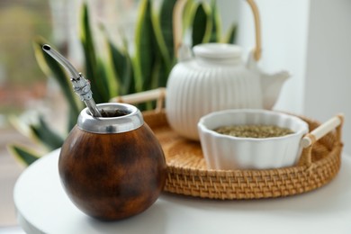 Photo of Traditional yerba mate tea on white table indoors, closeup