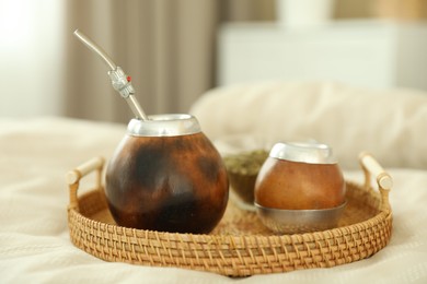 Photo of Traditional yerba mate tea on bed indoors, closeup