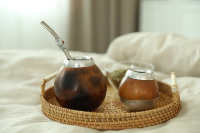 Photo of Traditional yerba mate tea on bed indoors, closeup