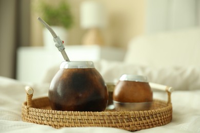 Photo of Traditional yerba mate tea on bed indoors, closeup