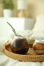 Photo of Traditional yerba mate tea on bed indoors, closeup