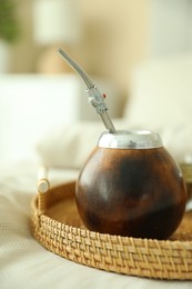 Photo of Traditional yerba mate tea on bed indoors, closeup