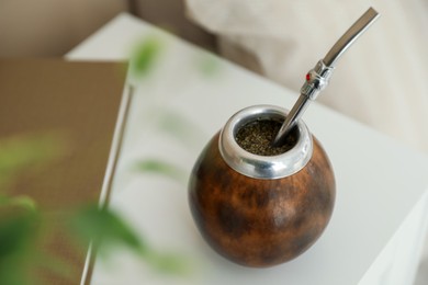 Photo of Traditional yerba mate tea on bedside table indoors, closeup