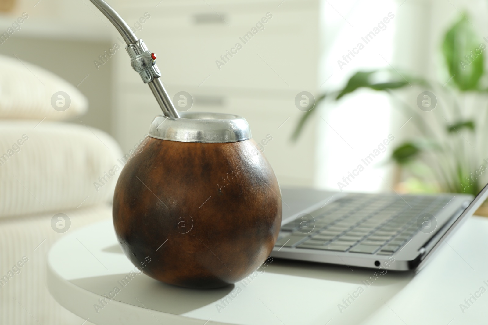 Traditional yerba mate tea and laptop on white table indoors, closeup Photo of Traditional yerba mate tea and laptop on white table indoors, closeup