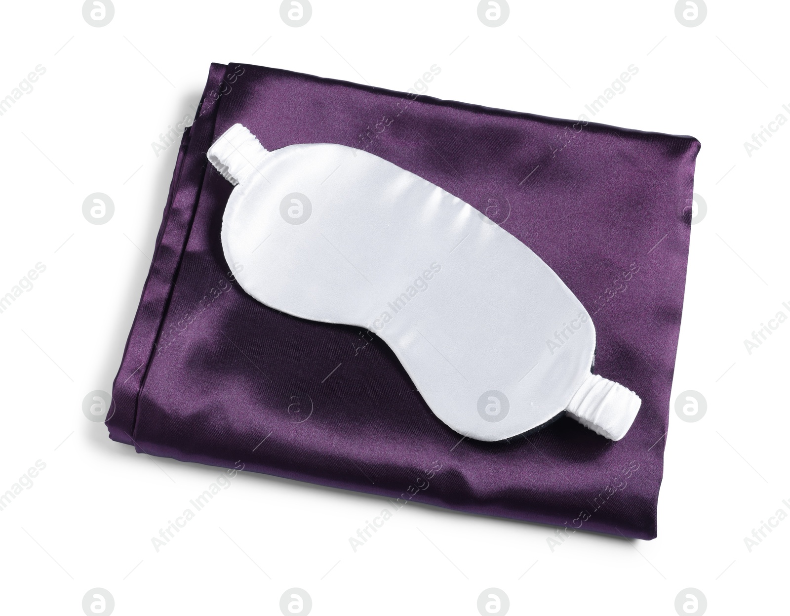 Photo of Silky bed linens and sleeping mask on white background, top view