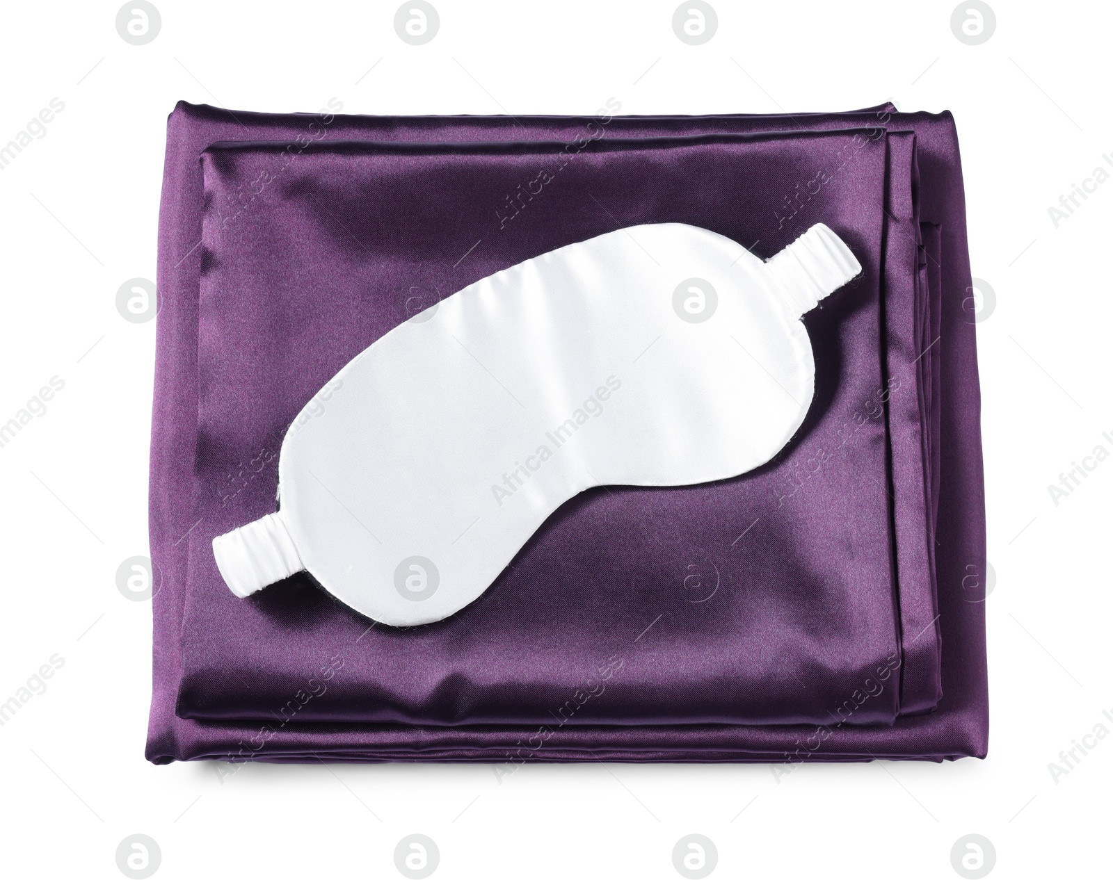 Photo of Silky bed linens and sleeping mask on white background, top view