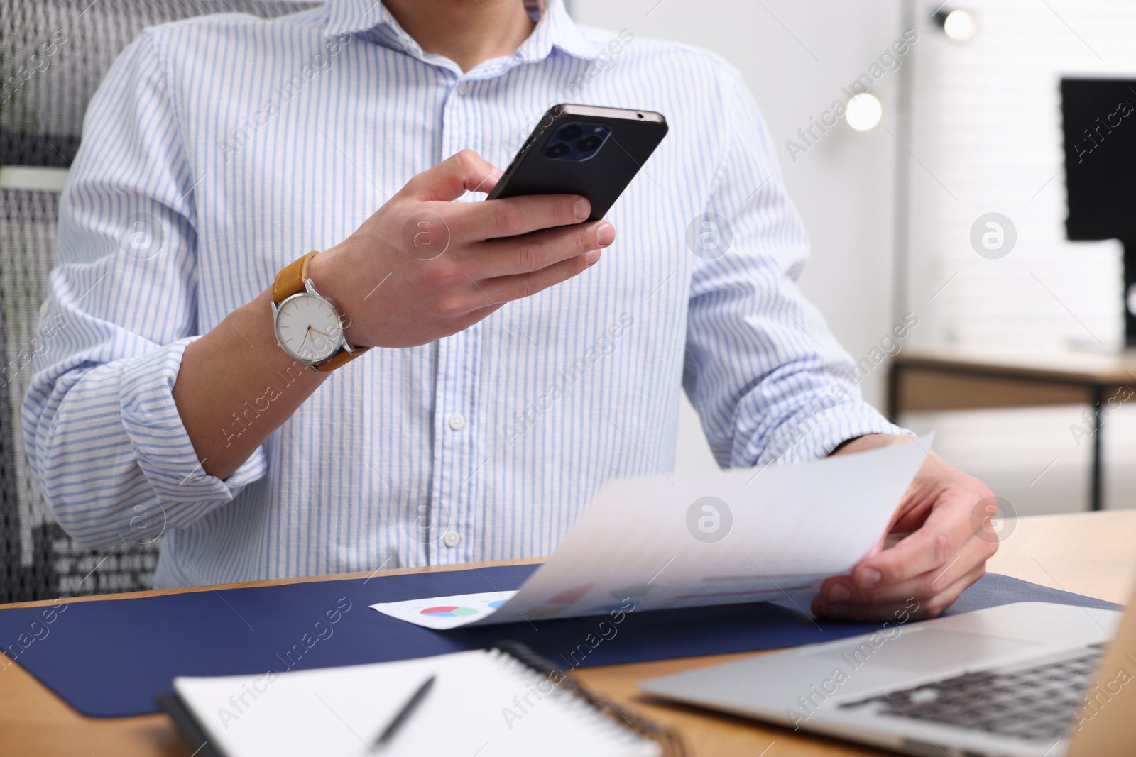 Man taking photo of document using scanning app on smartphone at desk in office, closeup Photo of Man taking photo of document using scanning app on smartphone at desk in office, closeup