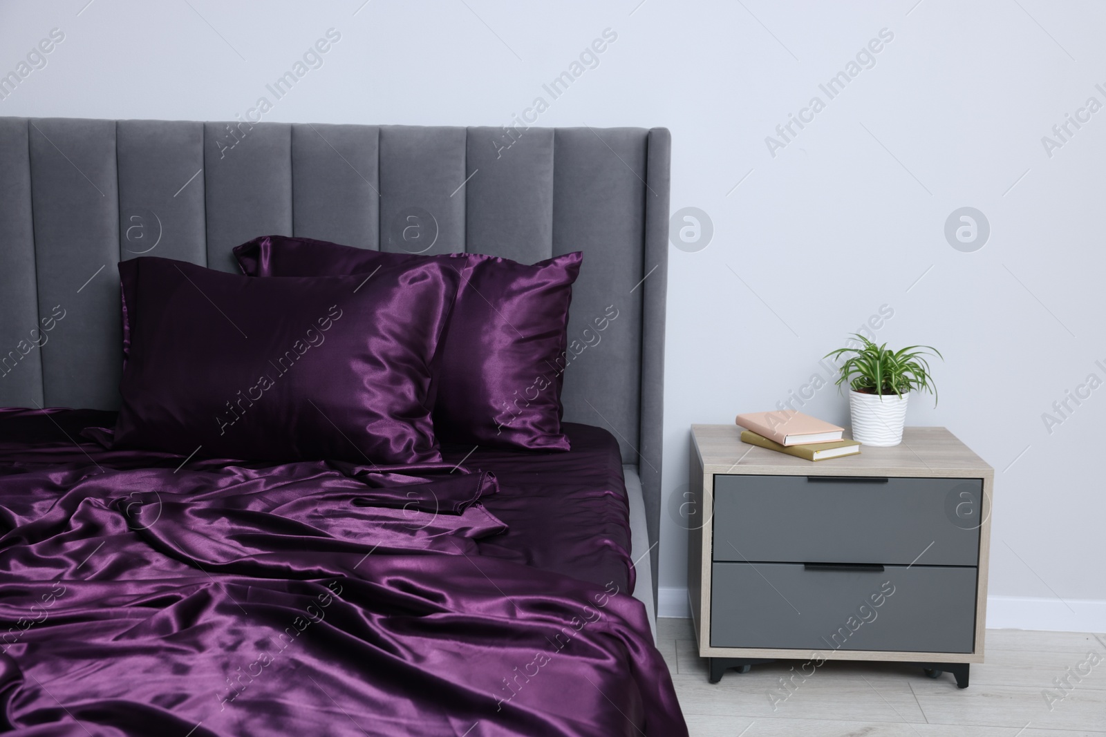 Luxury silk linens on bed and nightstand at home Photo of Luxury silk linens on bed and nightstand at home
