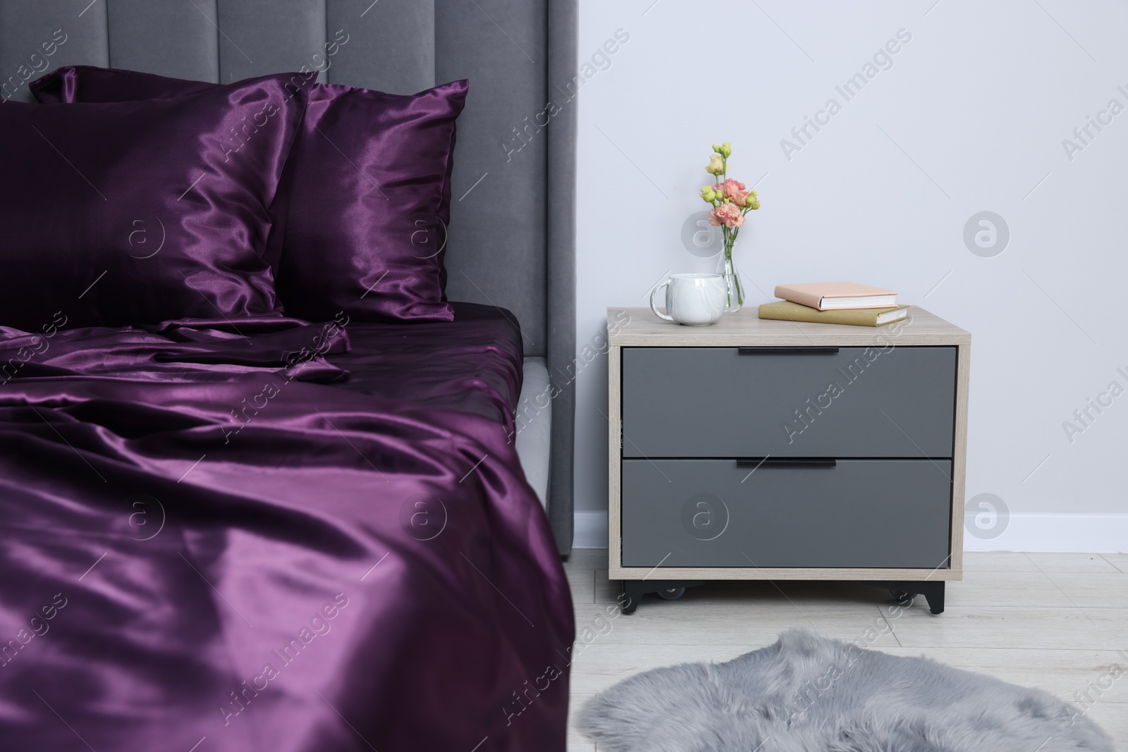 Luxury silk linens on bed and nightstand at home Photo of Luxury silk linens on bed and nightstand at home