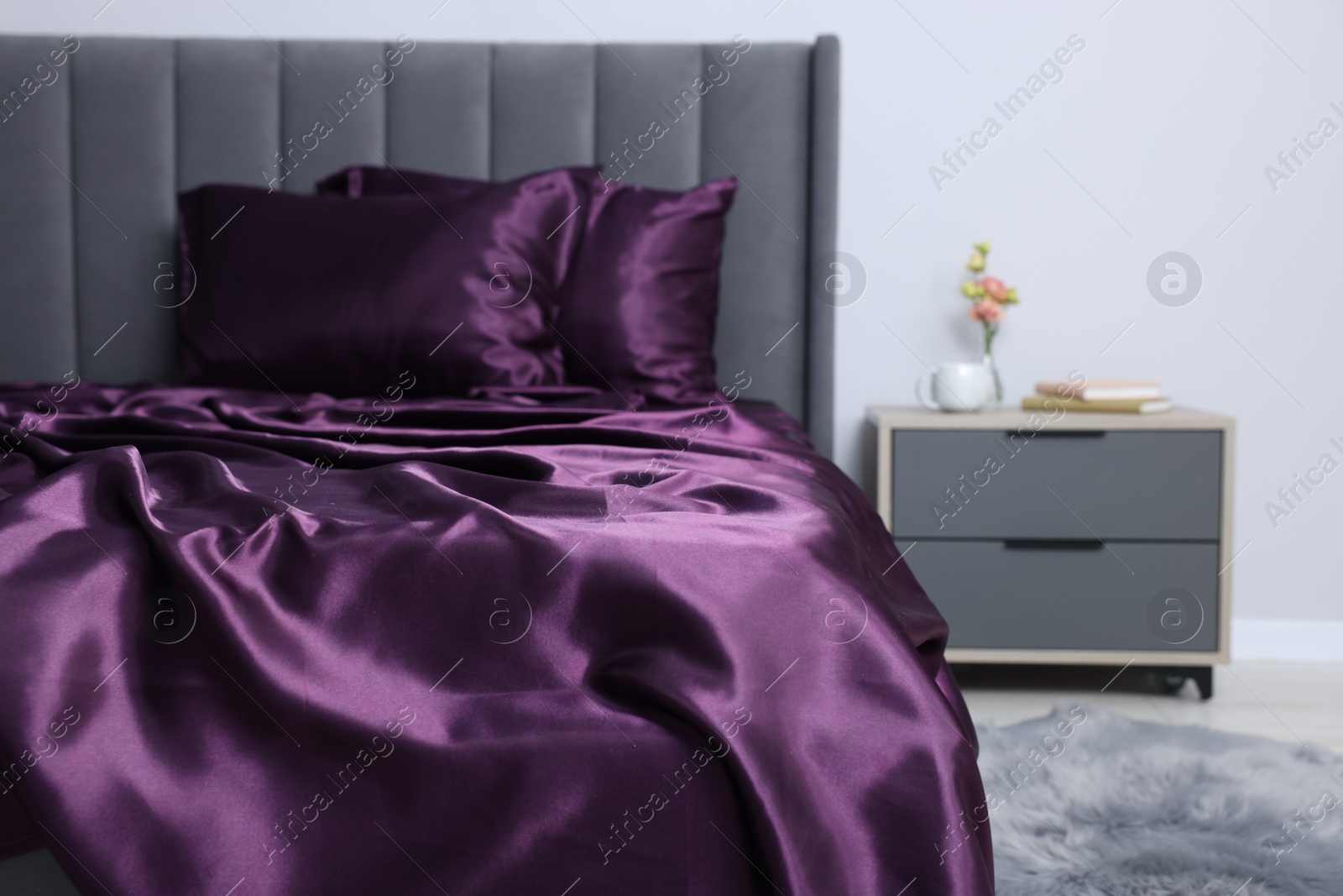 Luxury silk linens on bed and nightstand at home Photo of Luxury silk linens on bed and nightstand at home