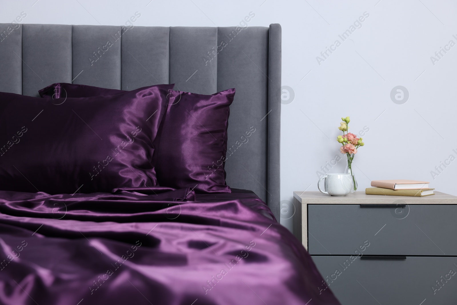 Luxury silk linens on bed and nightstand at home Photo of Luxury silk linens on bed and nightstand at home