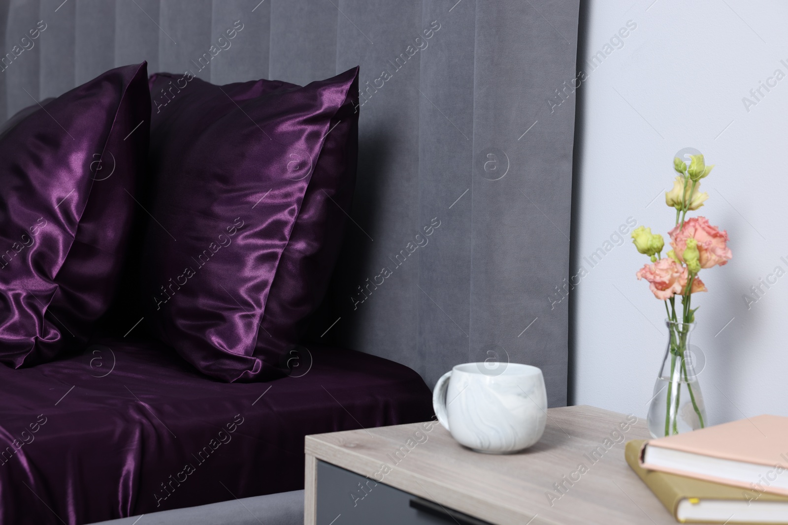 Luxury silk linens on bed and nightstand at home Photo of Luxury silk linens on bed and nightstand at home