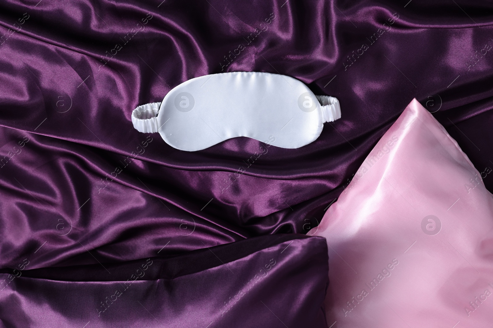 Luxury silk bed linens, pillows and sleep mask, top view Photo of Luxury silk bed linens, pillows and sleep mask, top view