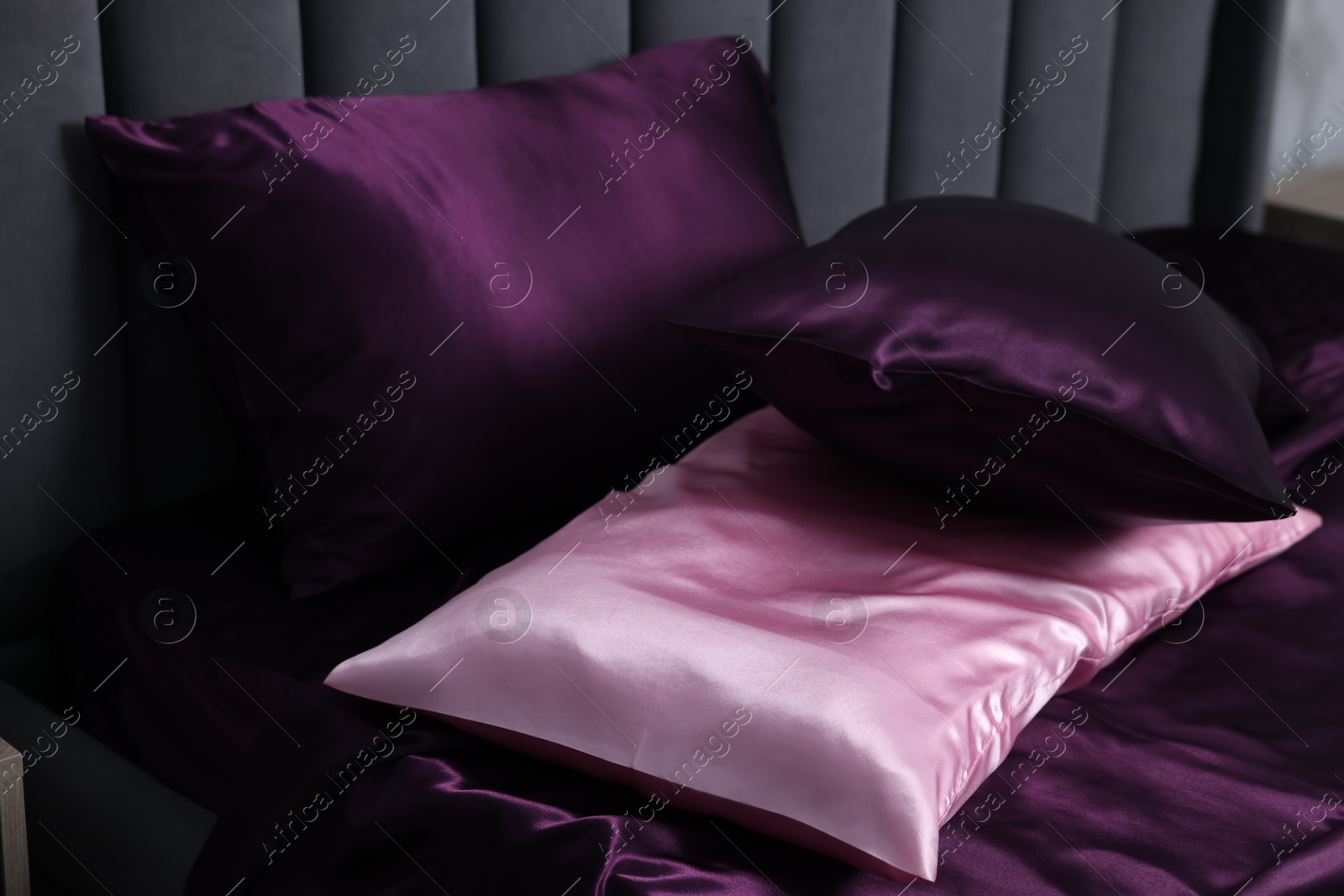 Luxury silk linens and pillows on bed Photo of Luxury silk linens and pillows on bed