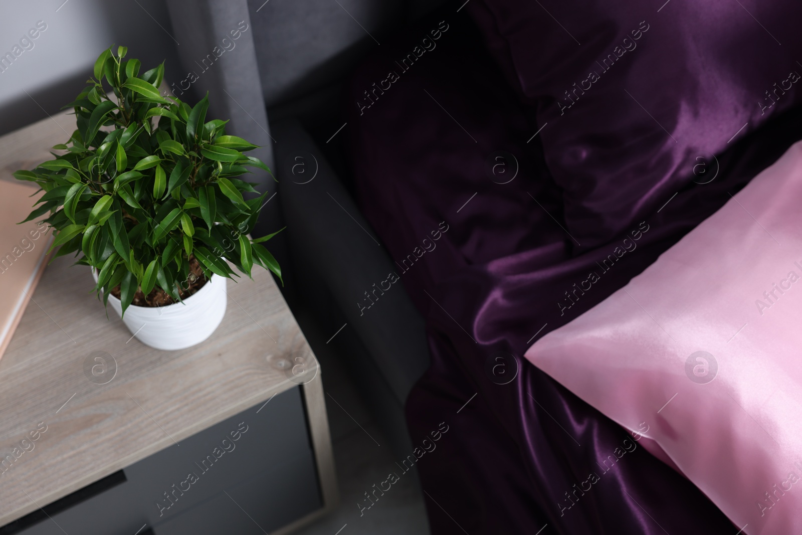 Luxury silk linens on bed and nightstand at home Photo of Luxury silk linens on bed and nightstand at home