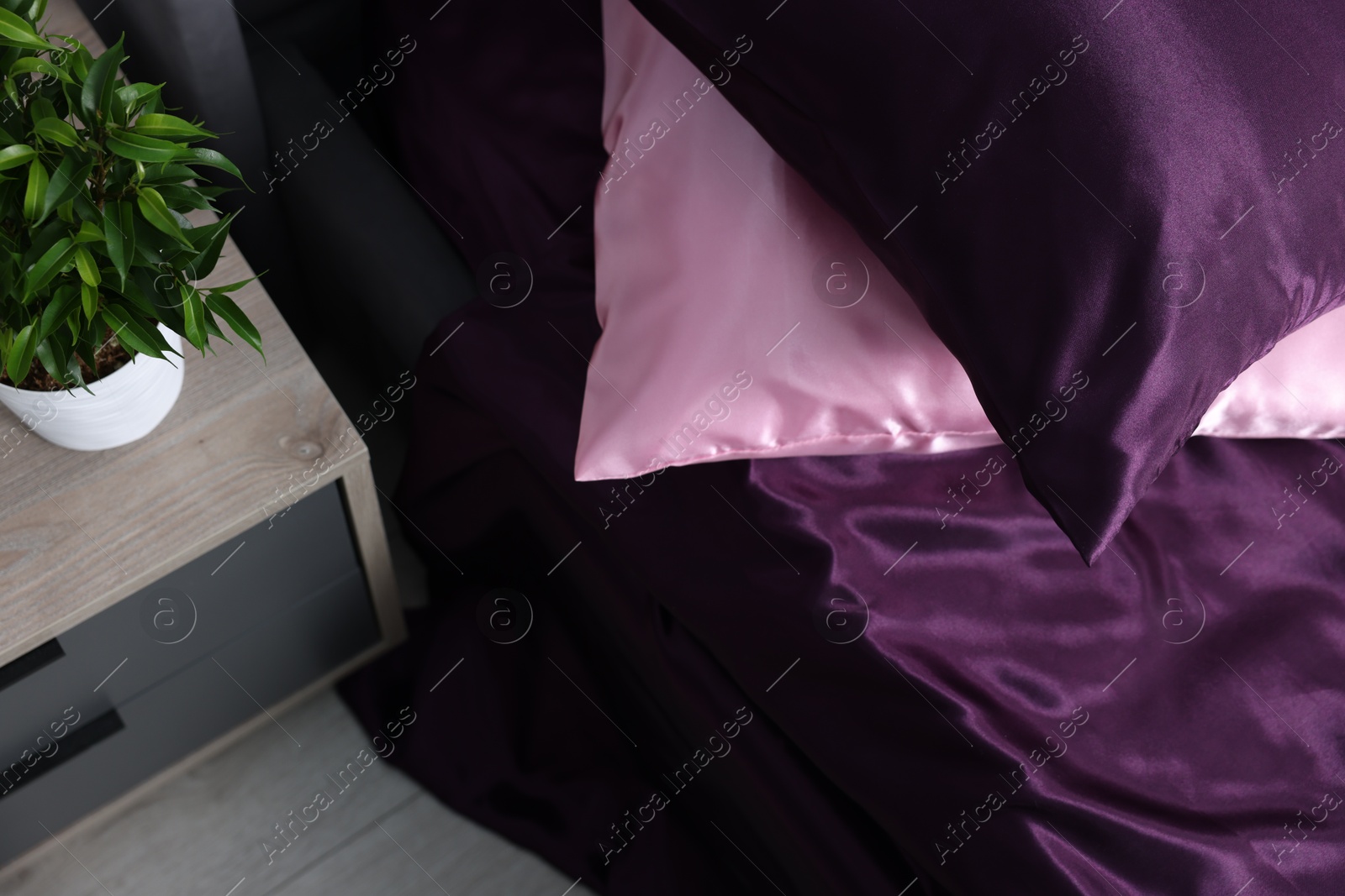 Luxury silk linens on bed and nightstand at home Photo of Luxury silk linens on bed and nightstand at home