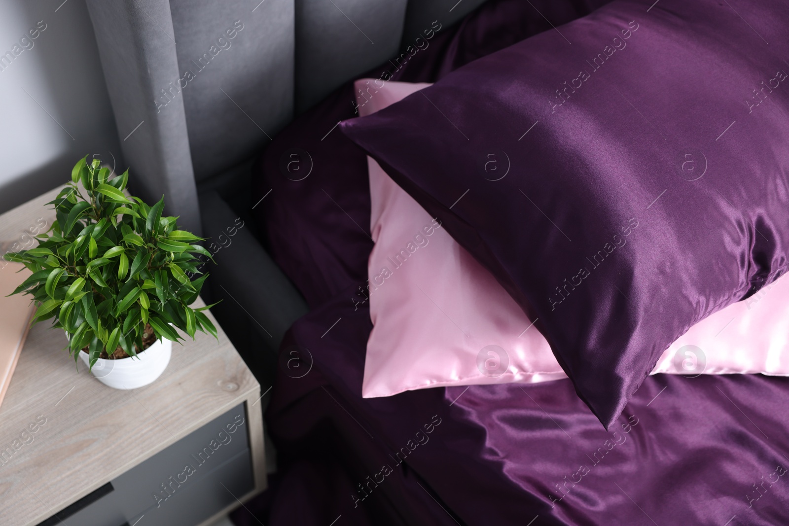 Luxury silk linens on bed and nightstand at home Photo of Luxury silk linens on bed and nightstand at home