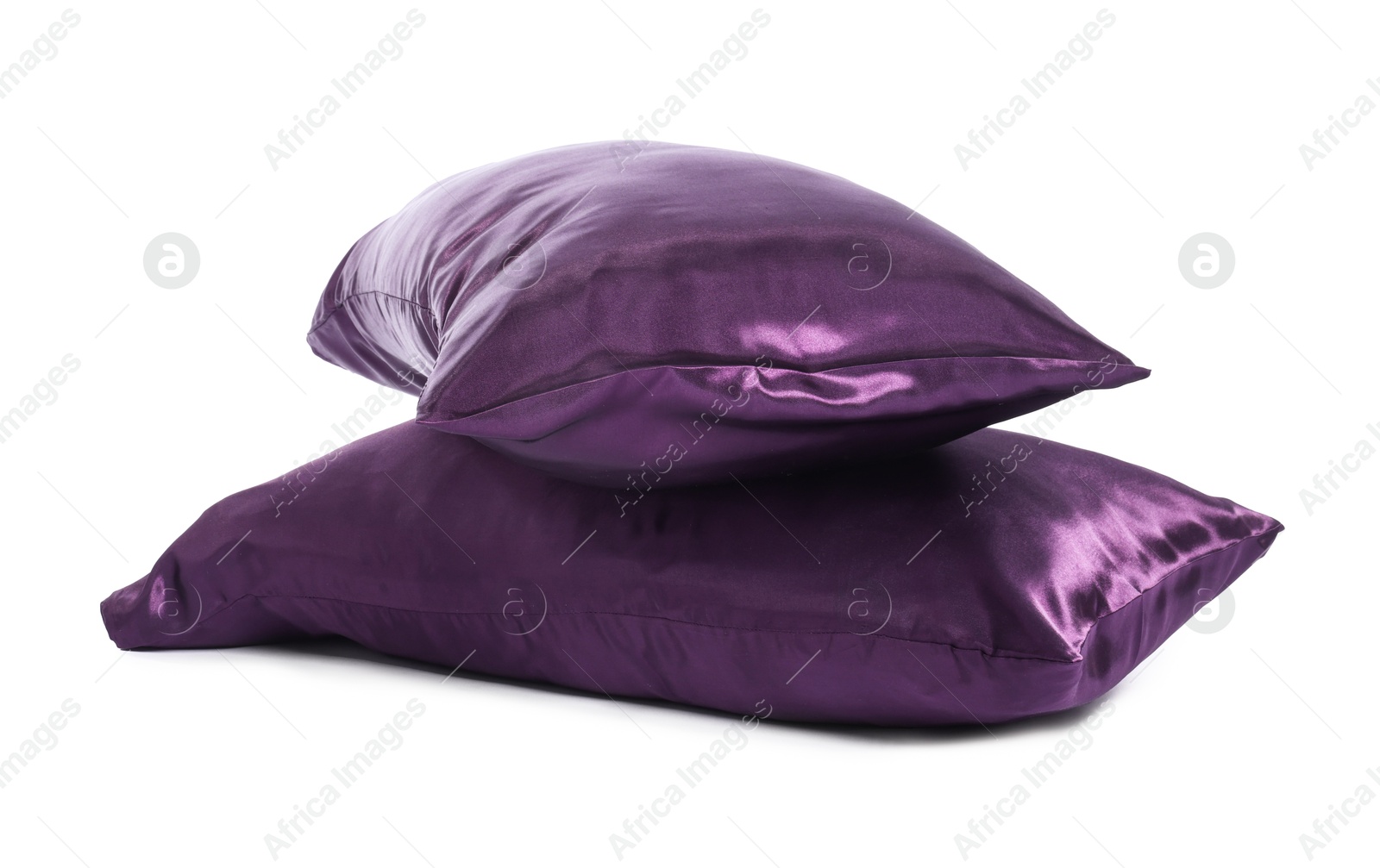 Pillows in purple pillowcases isolated on white. Silk bed linens Photo of Pillows in purple pillowcases isolated on white. Silk bed linens