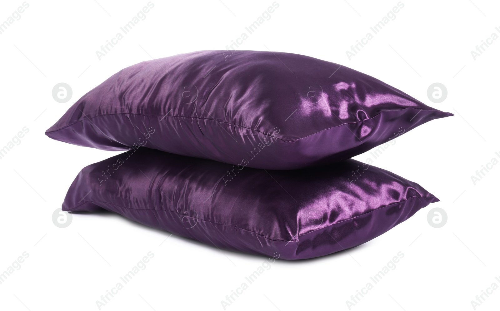 Pillows in purple pillowcases isolated on white. Silk bed linens Photo of Pillows in purple pillowcases isolated on white. Silk bed linens