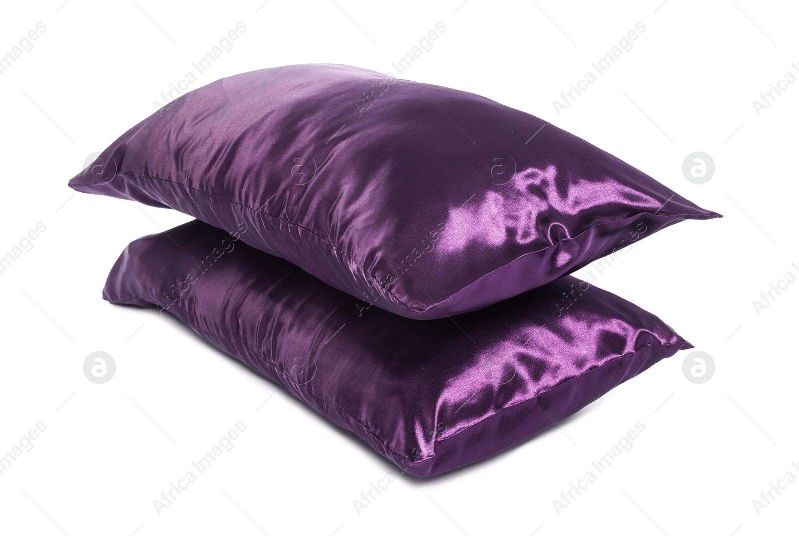 Pillows in purple pillowcases isolated on white. Silk bed linens Photo of Pillows in purple pillowcases isolated on white. Silk bed linens