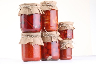 Photo of Many jars with different pickled products isolated on white