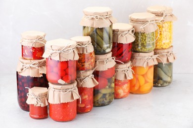 Photo of Many jars with different pickled products on light table