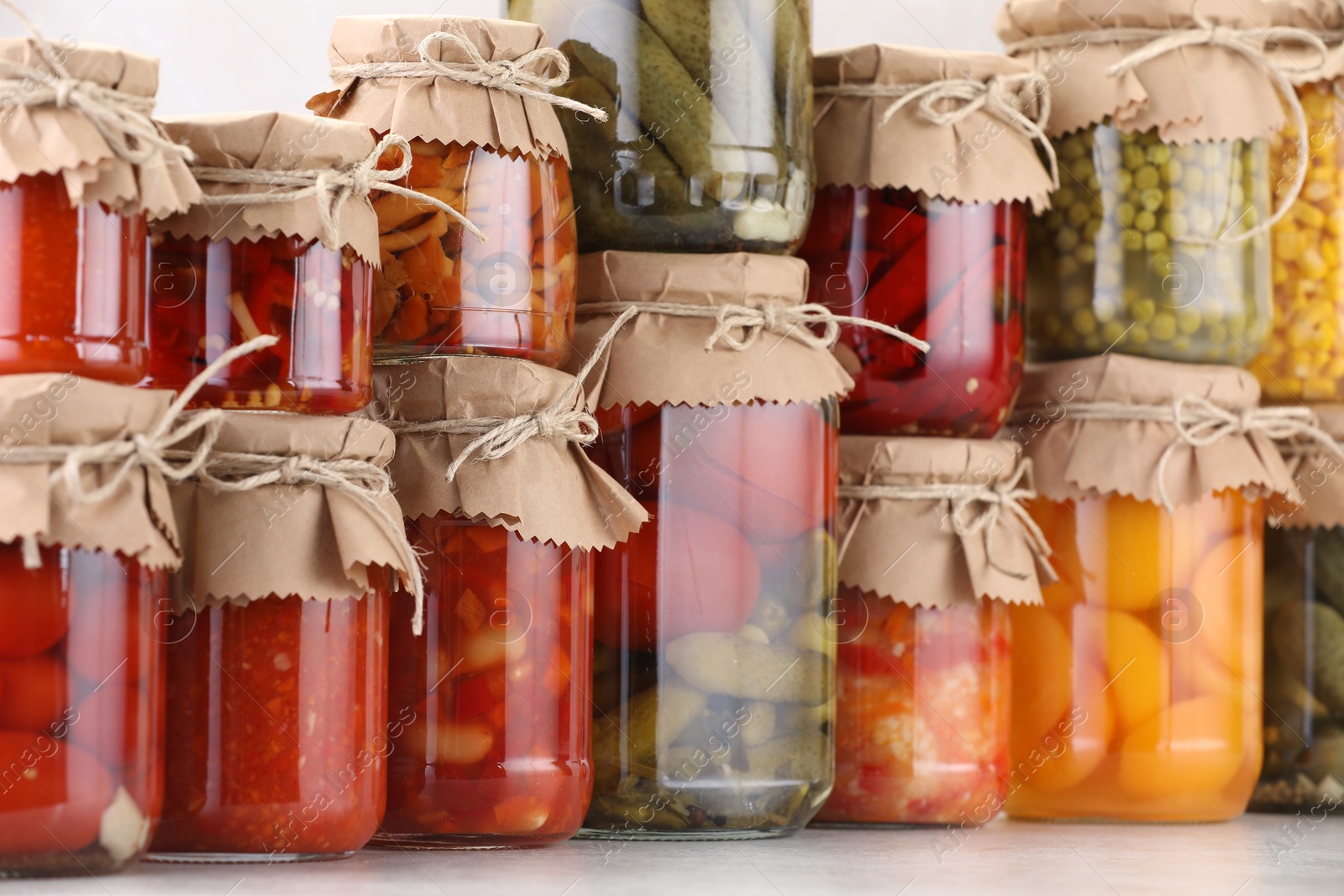 Many jars with different pickled products on light table Photo of Many jars with different pickled products on light table