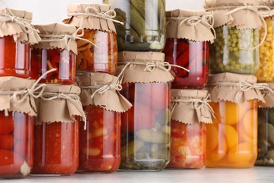 Photo of Many jars with different pickled products on light table